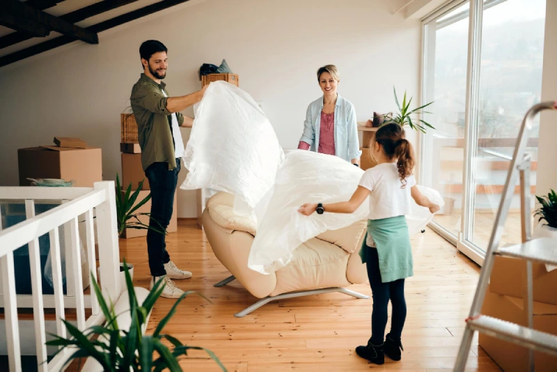 happy-parents-with-daughter-unpacking-furniture-while-moving-into-new-home